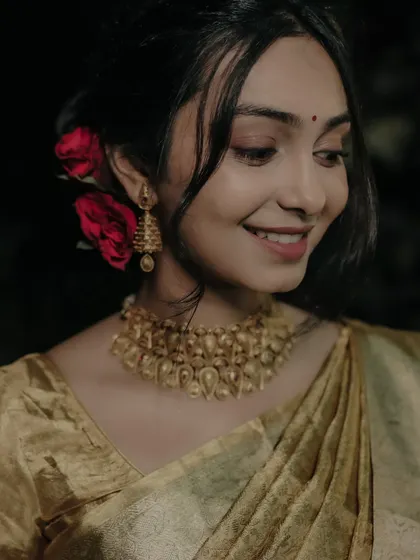 A detailed close-up of the bride-to-be, focusing on her happy smile and stunning gold jewelry.