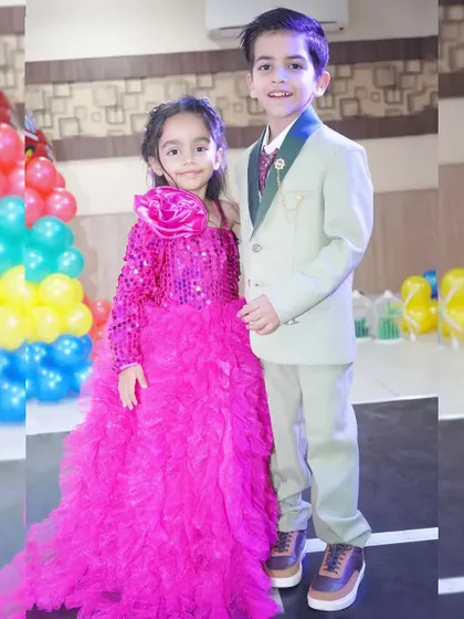 A brother and sister, dressed in their party best, pose for a photo together. We make sure to capture the special bond between siblings.