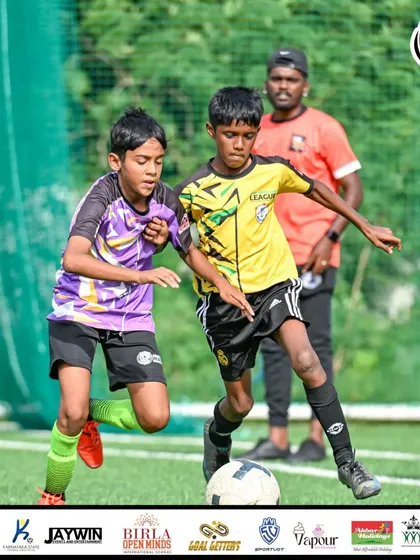 A tense moment as players challenge for the ball near the sideline.