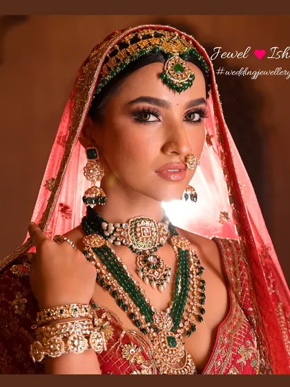 A close-up portrait that captures the intricate details of the layered necklaces, the delicate nath, and the matching earrings. Every piece works together to create a cohesive and stunning look.