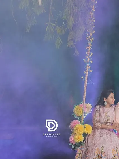 A dreamy and romantic pre-wedding photo using a decorated swing and colored smoke. This kind of setup can add a magical, ethereal quality to your couple portraits.