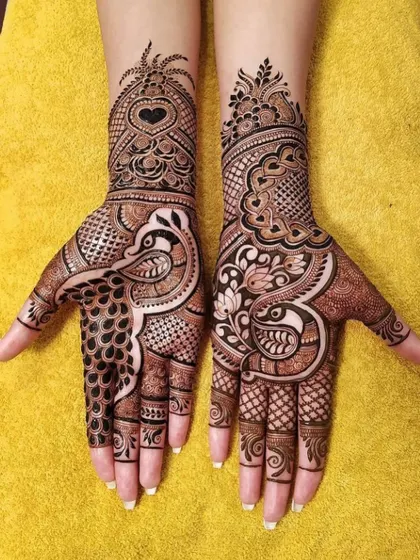 A striking fusion design featuring bold peacocks on the palms. The contrast between the dark, filled-in peacocks and the delicate surrounding patterns creates a powerful visual impact.