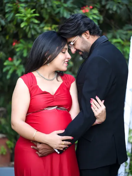 An intimate and romantic close-up of a couple outdoors. They are touching foreheads, sharing a quiet moment of connection.