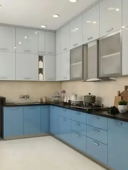 This L-shaped kitchen combines light blue and white cabinets for a bright and airy feel. The layout includes space for a dishwasher and microwave, showing smart appliance integration.