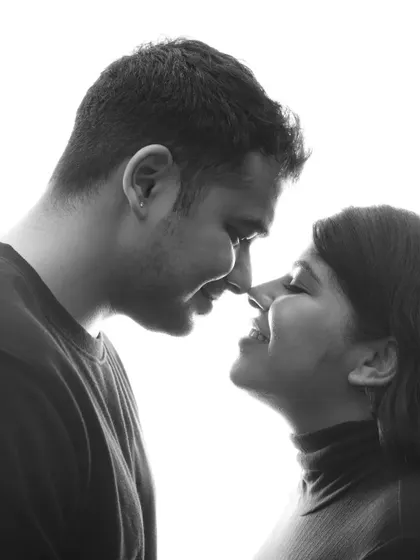 A playful and loving black and white close-up. This nose-to-nose moment between the expecting couple is full of joy and intimacy, a perfect candid capture.
