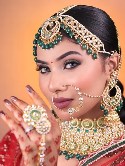 A close-up on the intricate matha patti and nath, paired with a bold lip and sharp eye makeup for a powerful bridal statement.