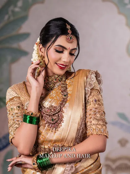 A lovely portrait of a bride in a golden saree, with a soft smile that shows she feels as good as she looks.