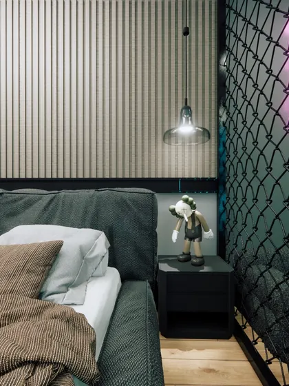 A close-up of the bedside in the gamer's room, featuring an industrial-style pendant light and a chain-link partition.