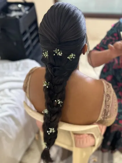 A clear shot of the sleek braid with baby's breath, a perfect hairstyle for an elegant, modern bride or bridesmaid.