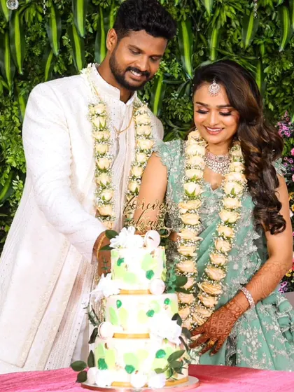 A candid shot of the couple cutting their three-tier green and white wedding cake. It's always an honor to be a part of these special memories.