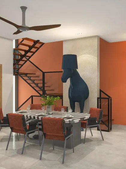 In this eclectic Nainital home, the dining area is defined by a bold orange accent wall and a quirky horse sculpture lamp, creating a playful yet stylish atmosphere.