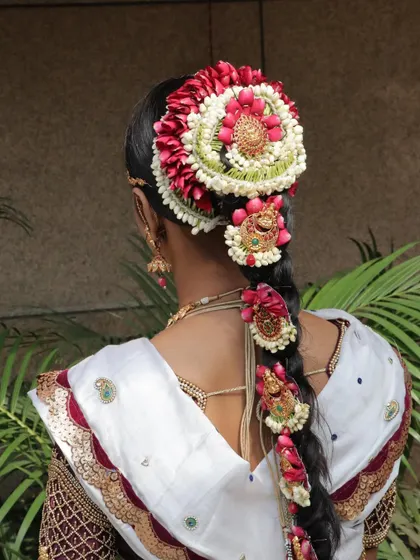 A view of the back, showcasing the elaborate floral hair arrangement, a masterpiece of traditional hairstyling.