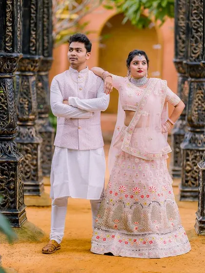 An elegant and regal portrait of a couple in beautiful pastel ethnic outfits. Their coordinated attire and poised stances create a sophisticated and timeless image.