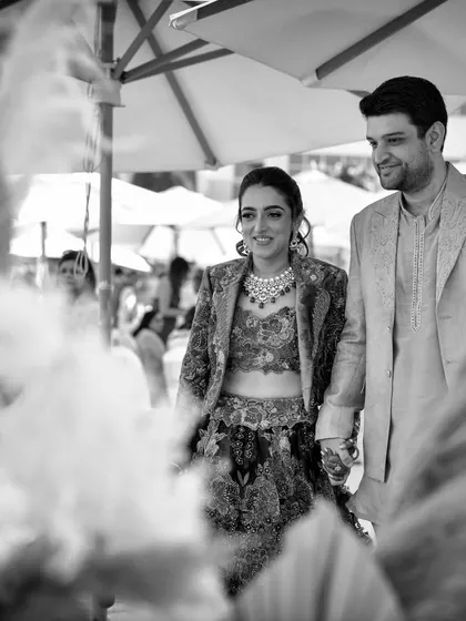 A beautiful black and white shot of the couple's entry, framed by pampas grass, capturing the soft, romantic feel of their welcome lunch.