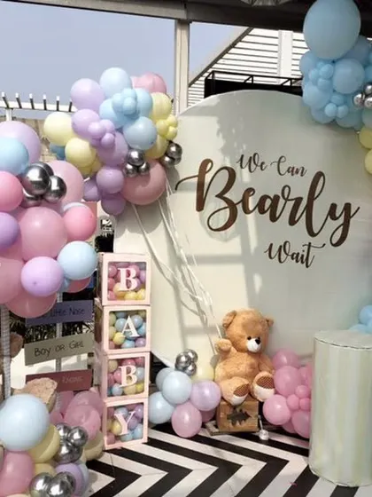 This outdoor baby shower setup shows a full view of the "We Can Bearly Wait" theme in a pastel palette. The decor is set against a striking black and white floor, making the colors pop.