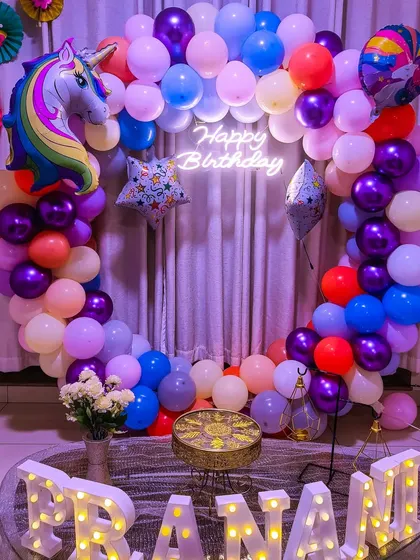 A colorful unicorn-themed birthday with a full ring of multi-colored balloons and a large unicorn foil balloon.