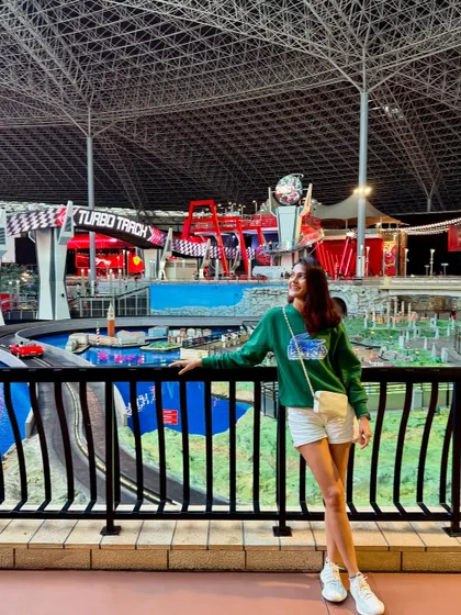 A fun day at Ferrari World in Abu Dhabi. My casual outfit of a green sweatshirt, white shorts, and sneakers was perfect for enjoying all the rides and attractions at this massive indoor theme park.