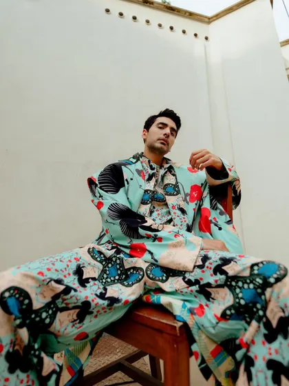 An editorial portrait of actor Ishwak Singh for Hindustan Times. The low-angle shot and vibrant, patterned suit create a powerful and confident image, showcasing a blend of personality and high fashion.