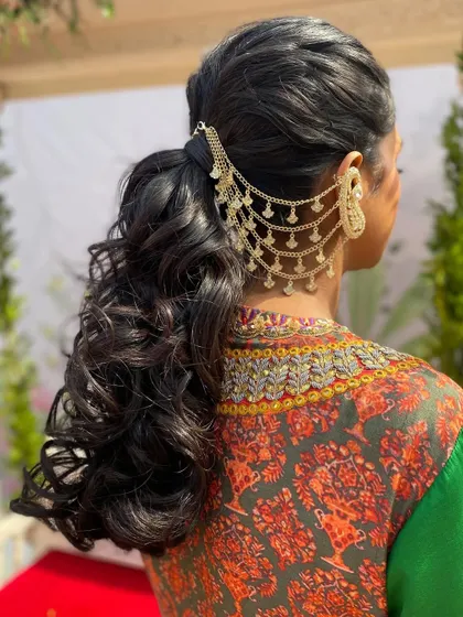 The back view highlights the beautiful curls and the intricate gold accessory that makes this ponytail truly special.