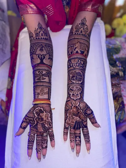 This full-arm design tells a complete wedding story. It includes a doli scene, a tree of life, and the couple exchanging garlands, all rendered in fine detail.