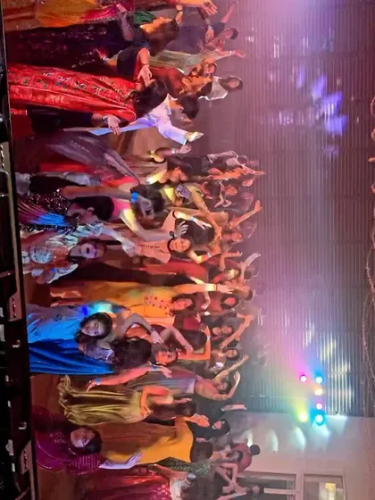 A fantastic group photo on the dance floor. This was at a vibrant sangeet night where everyone was in high spirits.