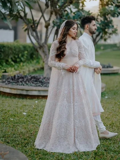 A full-length portrait of a couple in a beautiful garden setting. Her elegant gown and his classic sherwani are perfectly complemented by the natural surroundings, creating a graceful and timeless pre-wedding photograph.