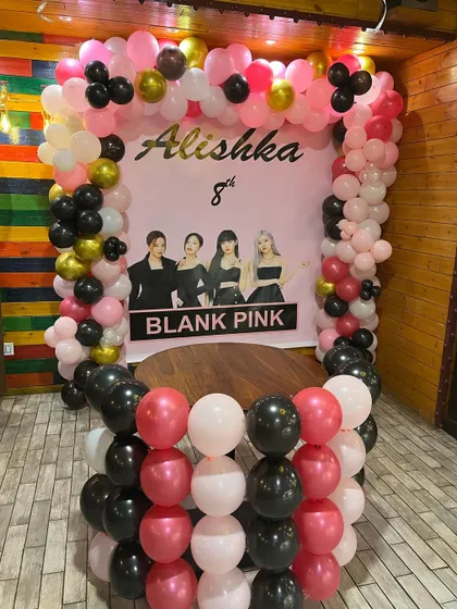 A close-up of the Blackpink themed birthday backdrop. The setup features a balloon frame in pink, black, and gold, perfect for photos.