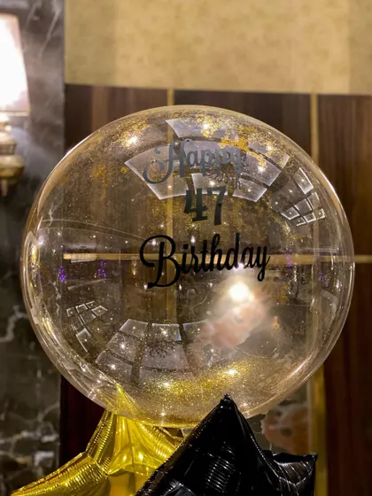 A close-up of the customized bubble balloon, wishing the recipient a "Happy 47th Birthday". Personalization is key to making any gift or decor feel special.