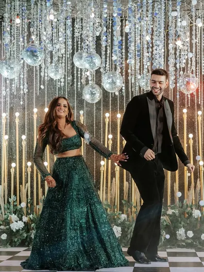 We turn the Sangeet night into a full-blown fairytale. This couple's first dance was set against a backdrop of sparkling disco balls and a classic checkered dance floor, creating a scene of pure energy and joy.