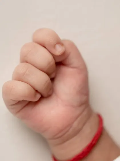 A tiny, clenched fist, a reminder of the strength and newness of life.