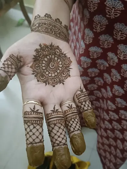 A simple yet elegant mandala on the palm, paired with net designs on the fingers.