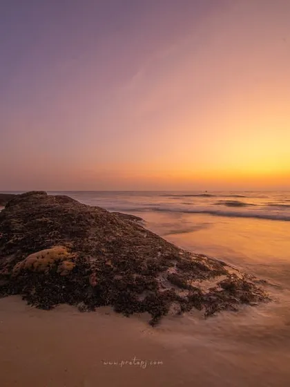 A long exposure of a sunset at Padubidri beach, with the poem by ChatGPT reflecting on the calm and delight of coastal life.