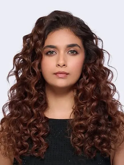A beautiful transformation for actress Keerthy Suresh, showcasing our Iconic Browns color service. We enhanced her natural curls with rich, warm tones for a healthy, radiant finish.