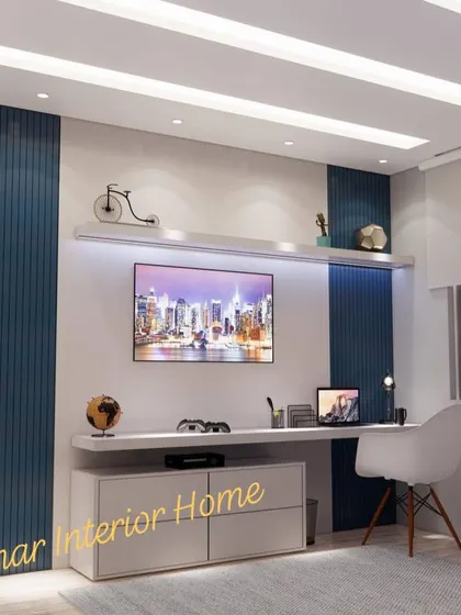 A bedroom with a blue and white color scheme, featuring a built-in desk and TV unit.