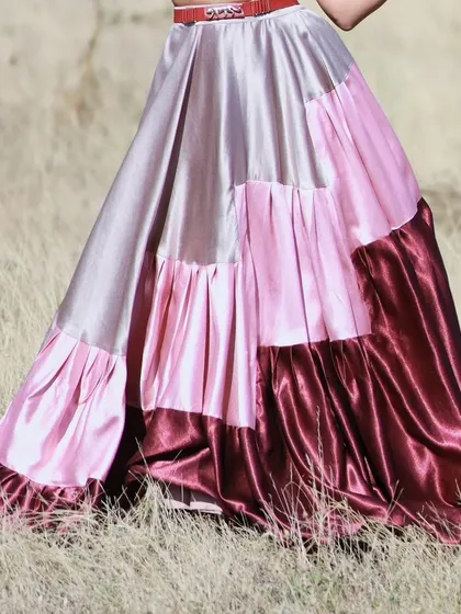 A close-up of the tiered, color-blocked satin skirt.