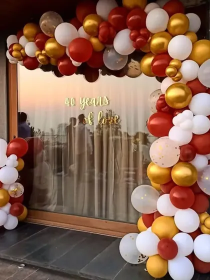 A classic balloon arch is a great way to frame an entrance or a view. This one, in red, gold, and white, was created for a 40th birthday celebration and adds a festive touch to the space.