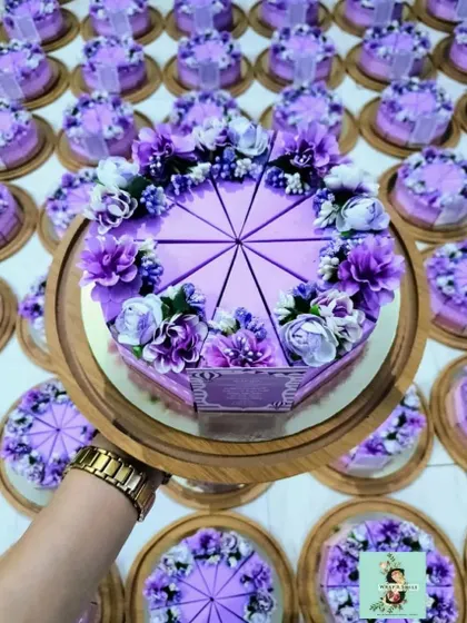 A top-down view of the lavender cake platters I created for a baby girl announcement. The floral details and individual pastry boxes make this a stunning and interactive gift.