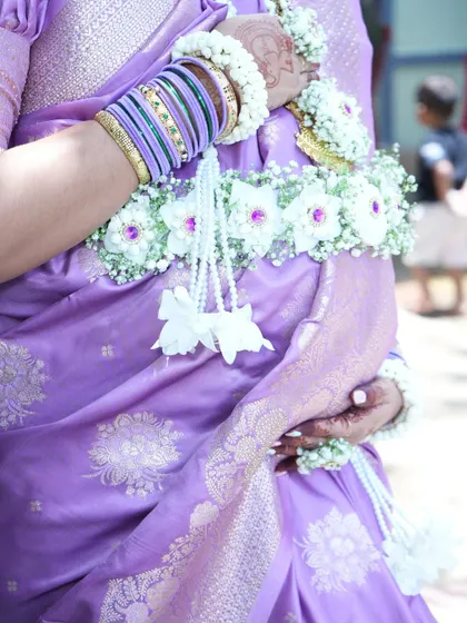 A close-up of the floral kamarband (waistband) from the baby shower set, showing the delicate arrangement of white orchids and baby's breath.