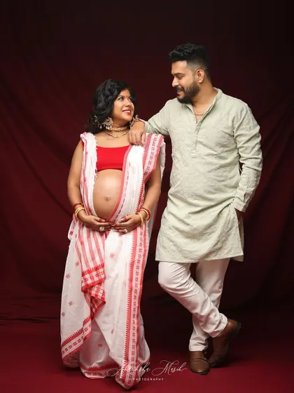 A beautiful portrait of an expecting couple in traditional Bengali attire. Their loving gaze towards each other speaks volumes.