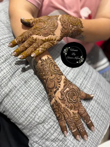 A rich floral design covering the hands. The combination of large flowers and smaller, detailed patterns creates a full and luxurious look.