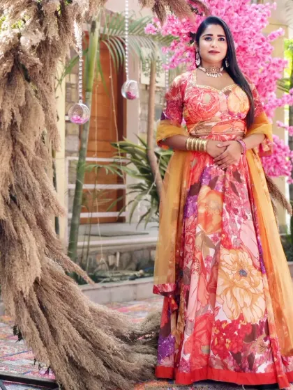A full-length shot showcasing my floral lehenga against the rustic-chic decor of the Mehndi event. The pampas grass arch was a beautiful touch.