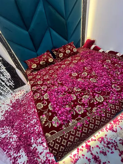 A close-up of the bed covered in rose petals, a key element of the romantic wedding night decoration service.
