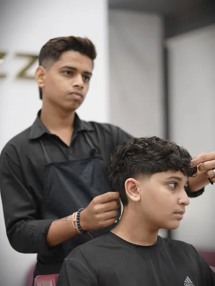 Here's one of my stylists working on the taper fade, ensuring every detail is perfect.