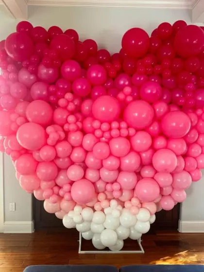 This large heart-shaped balloon wall is a real showstopper. It features an ombre gradient of pinks and white, creating a beautiful and artistic backdrop for Valentine's Day photos.
