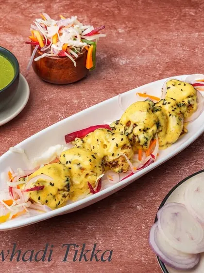 Awhadi Tikka is known for its subtle and aromatic flavors. These kebabs are marinated in a light, creamy mixture with delicate spices and poppy seeds, resulting in a very tender and flavorful bite.