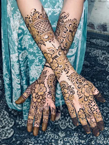 A crossed-hands pose showing the beautiful symmetry of the floral design. This is a popular choice for brides and guests alike.