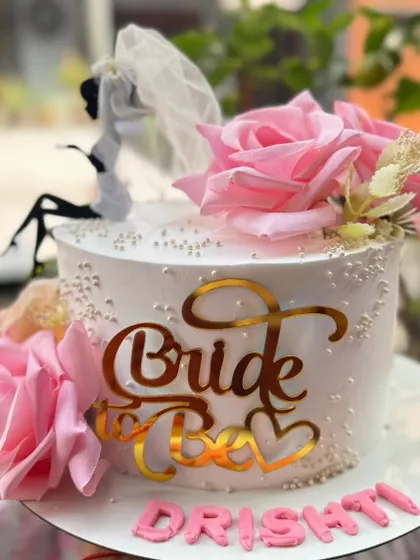 A chic "Bride to Be" cake with pink roses and a stylish topper.