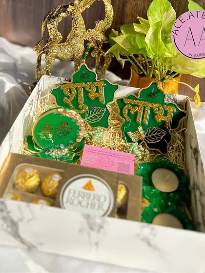 Another look at the green Diwali hamper, this one featuring intricate butterfly and leaf details on the Shubh Labh hangings.
