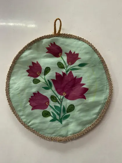 A completed fabric painting of magenta flowers, framed in a circular hoop. This can be used as wall art or as a decorative patch on a garment or accessory.