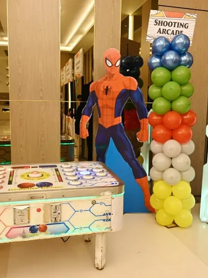 A view of the game zone at the superhero party, featuring multiple arcade machines.